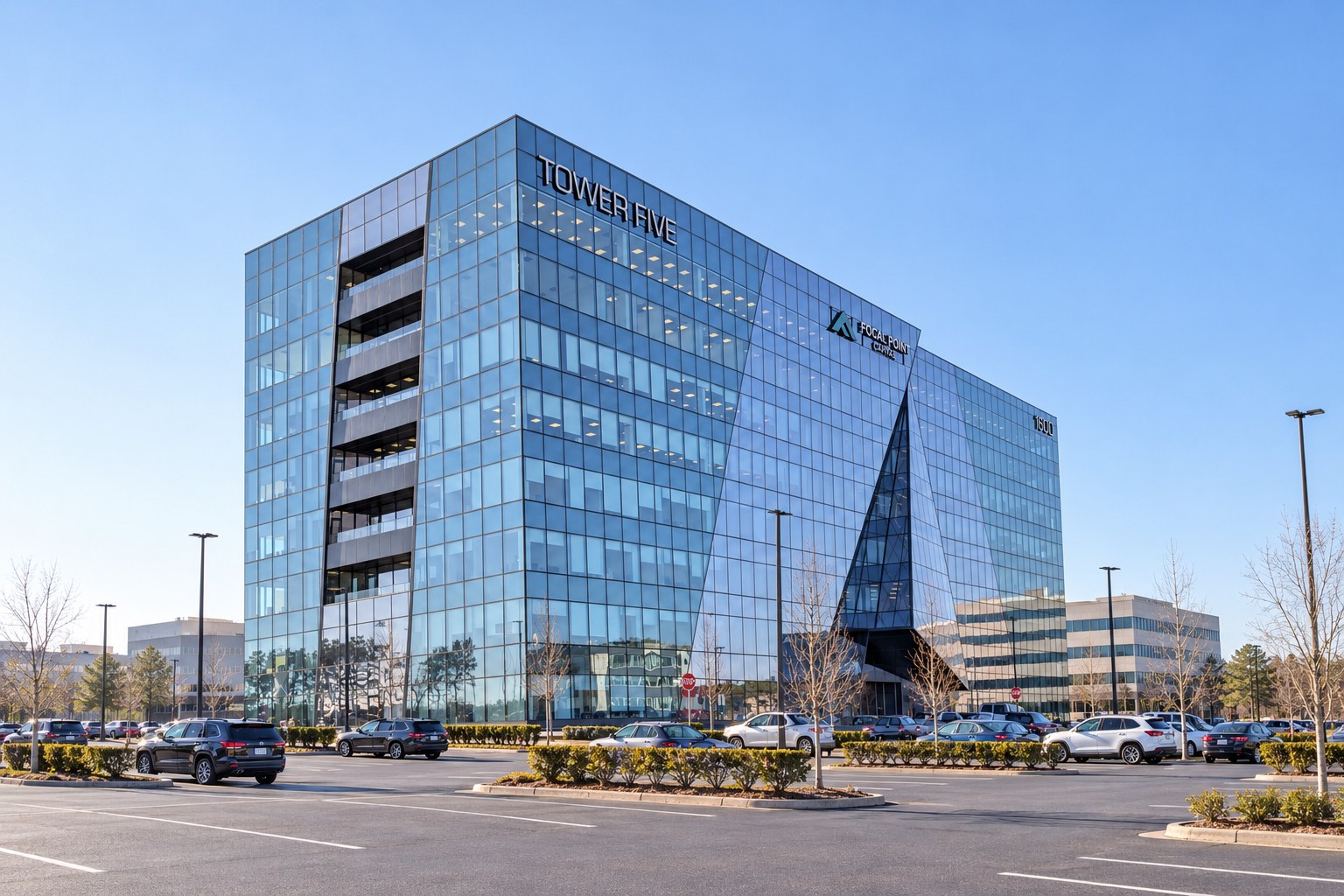 Tower Five, a glass office building with a faceted corner, under a clear blue sky