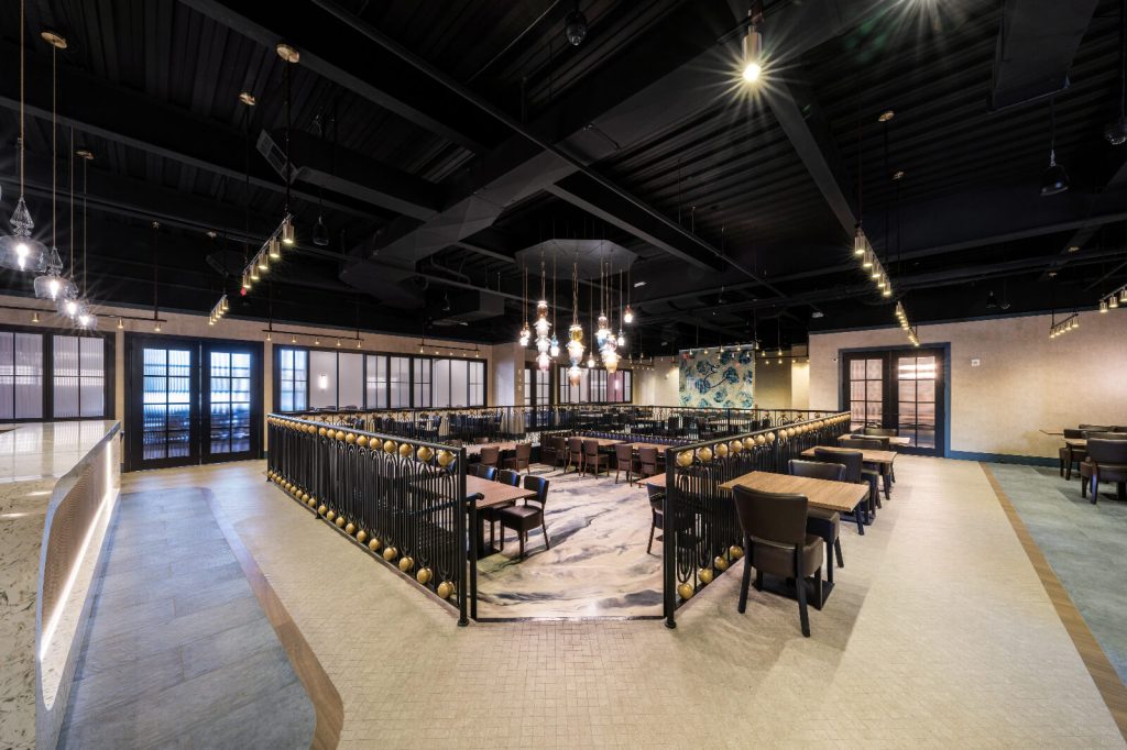 Interior of the Entree restaurant dining room with pendant lighting and a railed upper level